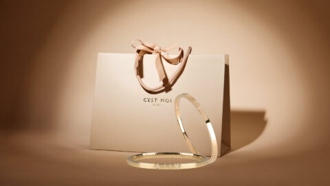 arangemet van 2 gounden bangle armbanden met cadeauverpakking op achtergrond